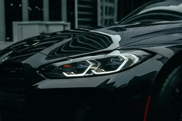 Front eines schwarzen BMW mit eingeschaltetem LED-Scheinwerfer